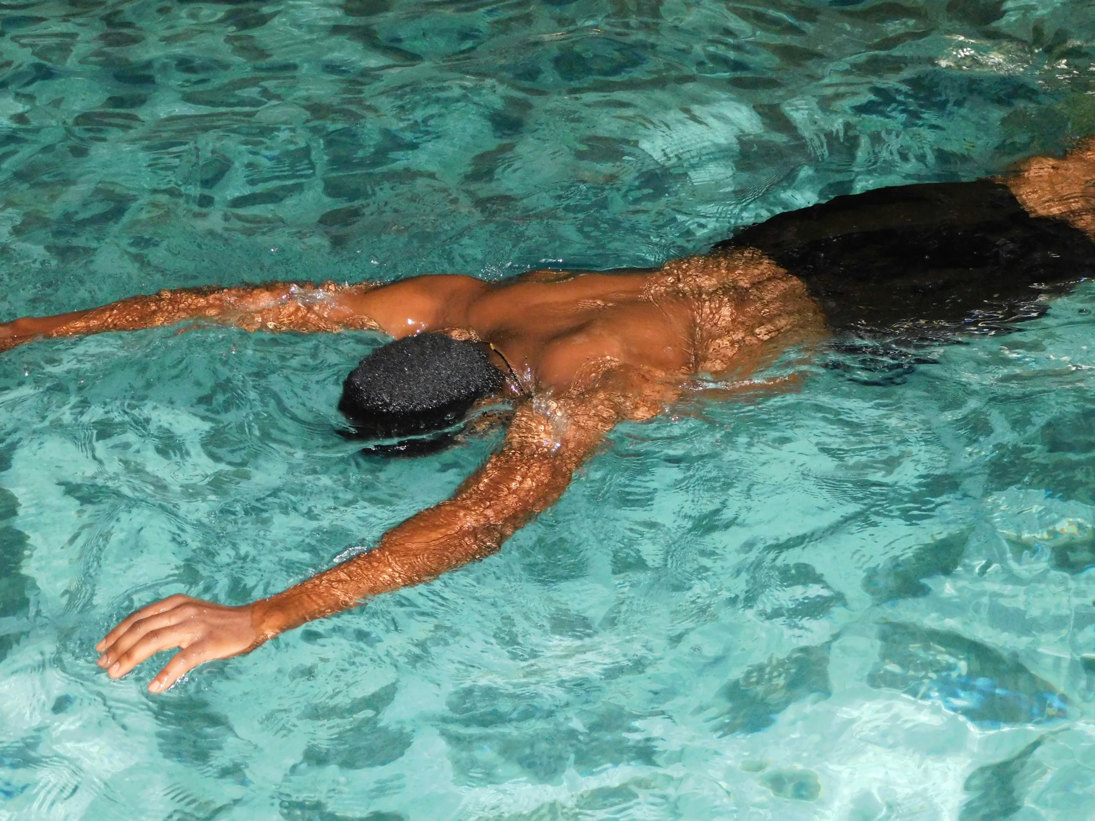 an athlete is swimming in the blue water