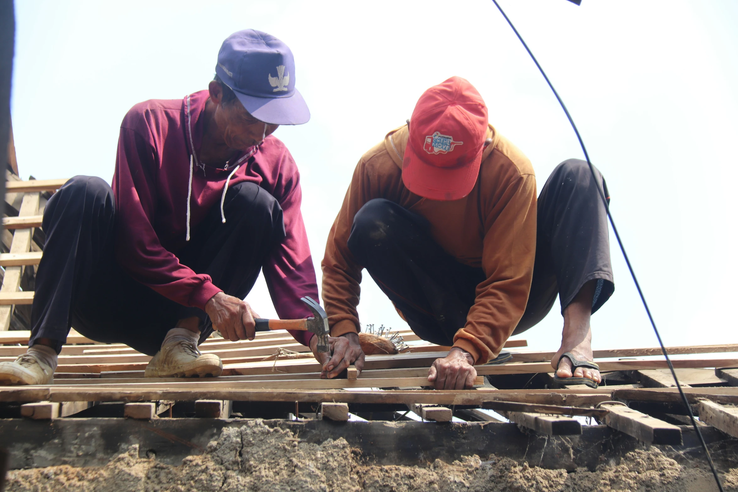 two men are making a wooden wall in the process of build