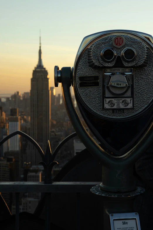 a metal coin operated observation overlooks a city skyline