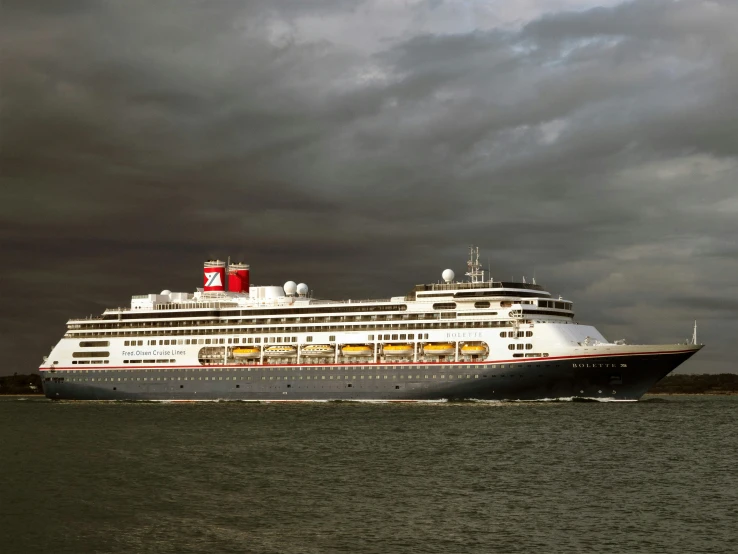 a cruise ship traveling through the water on a cloudy day