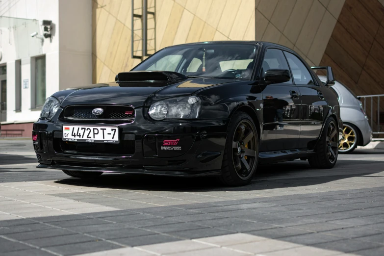 a black sports car parked on the street in front of a large wall