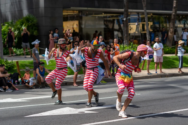 two people dressed in colorful costume walking down the street