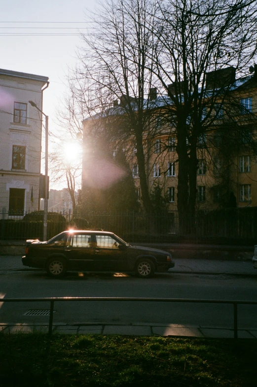 the car is driving down the road near some houses