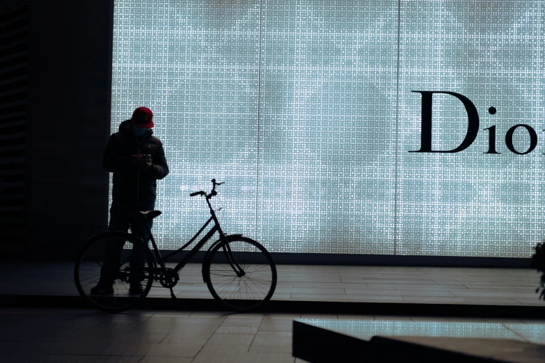 the person wearing a red hat is standing by a bicycle