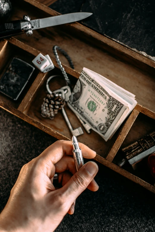 a person holding a pen and some money