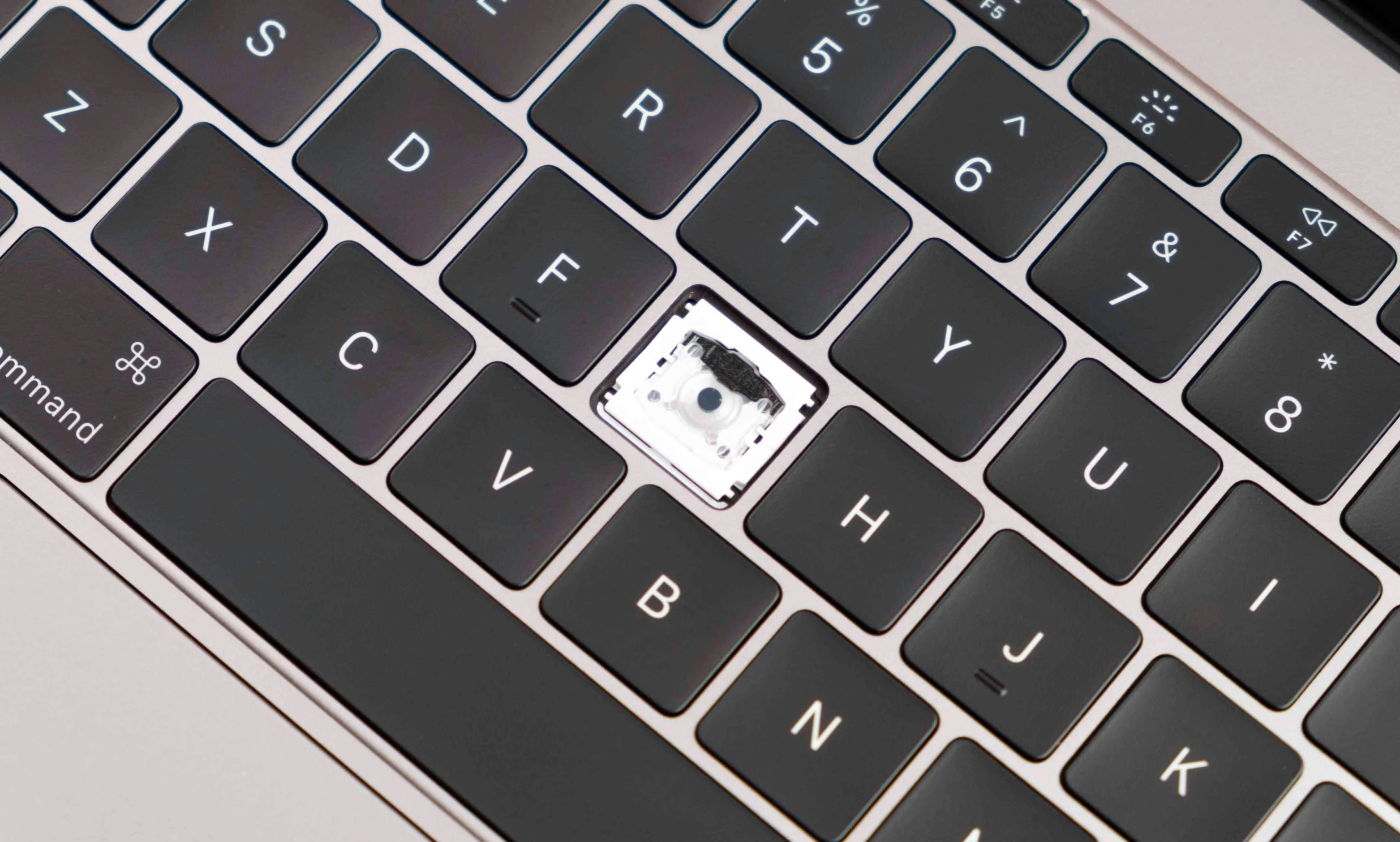 a laptop with the keys on it has a small square chip in the middle