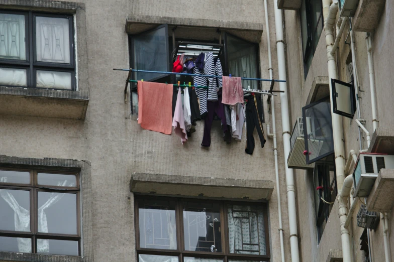 clothes hanging out of a window in an apartment building
