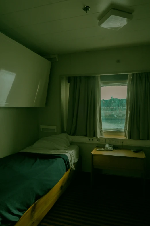 a dimly lit room with two beds in front of the window