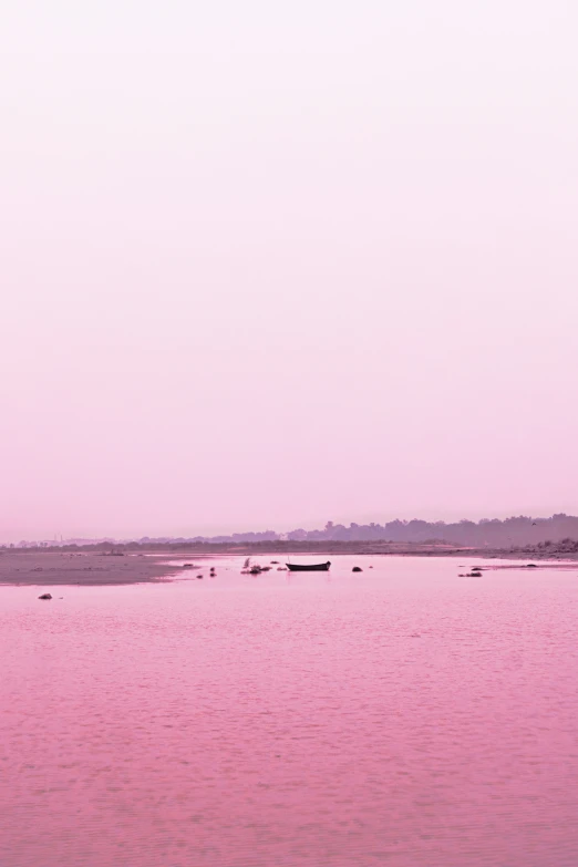 two boats are floating on the water at dusk