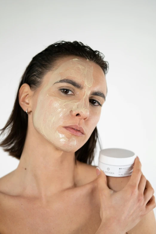 a woman with a jar of scrub on her face