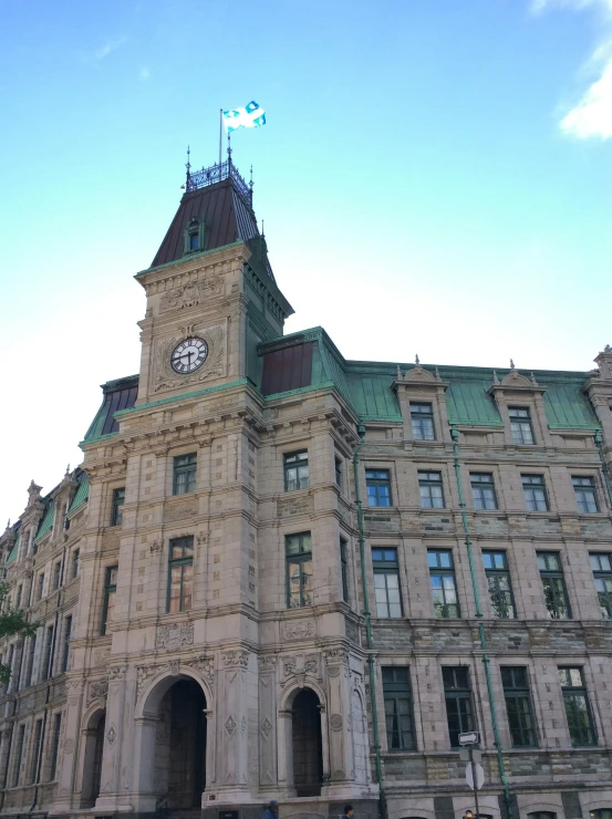 a large clock on top of a tan building