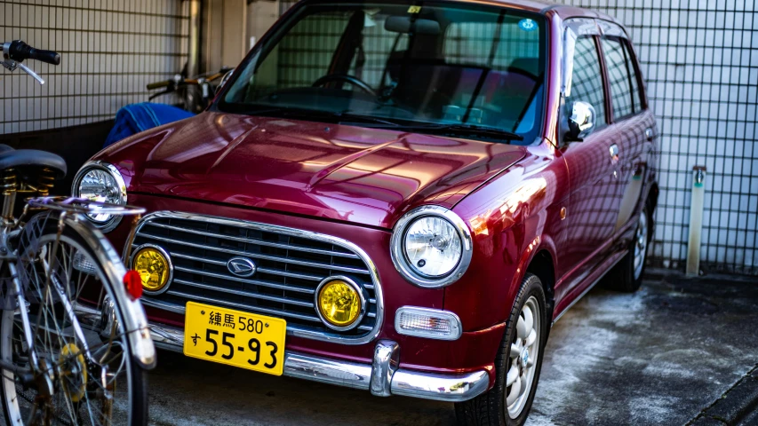 there is a red car and a bicycle in front of it