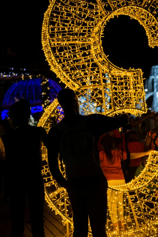 people standing next to a sign with the number 9 lit up at night