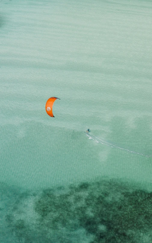 an orange kite is flying in the air