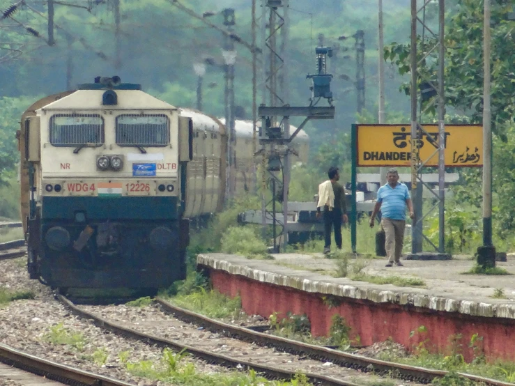 a passenger train sits on the tracks in a rural country setting