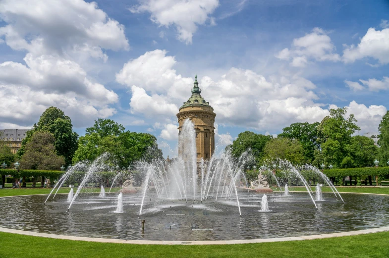 a water fountain in front of a building and trees