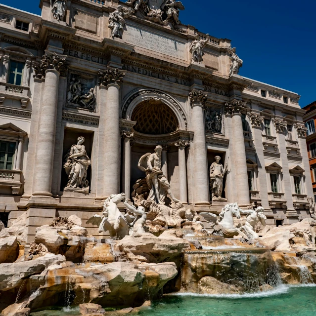 a large building has a fountain in front of it