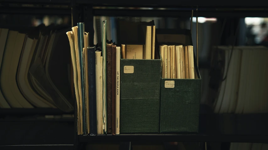 several books with stick pens in a bookshelf