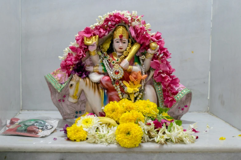 a figurine on a bench surrounded by flowers