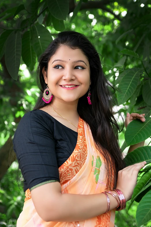 the woman is smiling in her orange sari