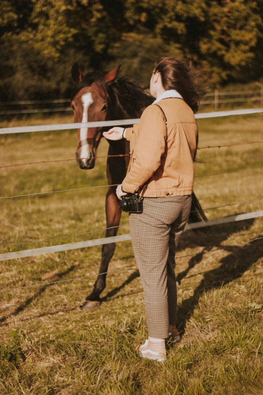 a woman standing next to a horse in an enclosure
