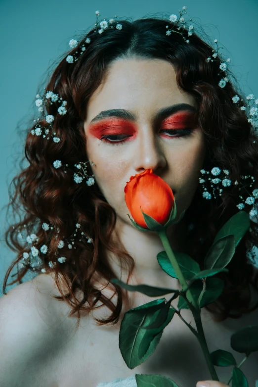 a woman with flower in her mouth and makeup on