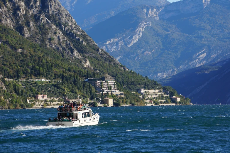 a white boat out in the water near some mountains