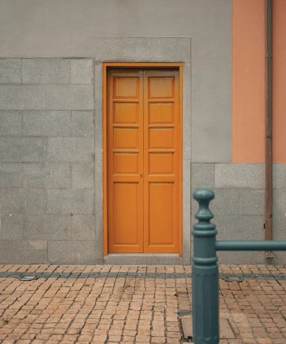 a large wooden door and light grey stucco building