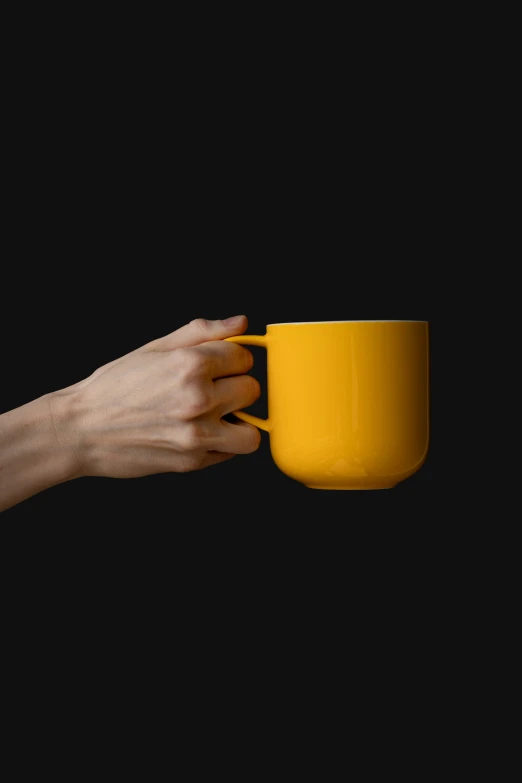 yellow mug being held up by two hands