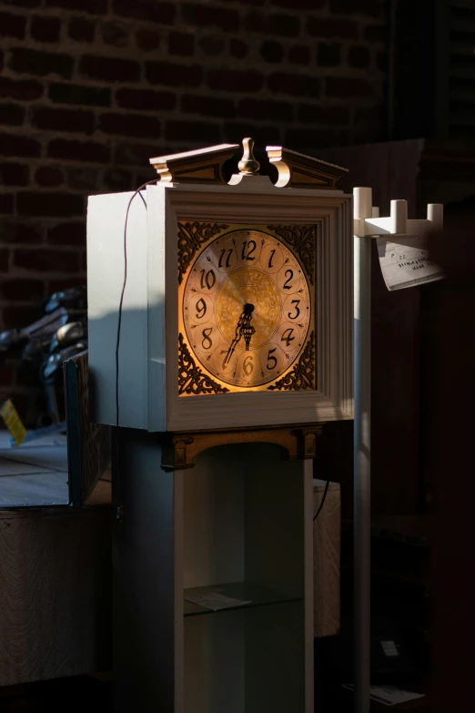 an old clock sitting on top of a white shelf