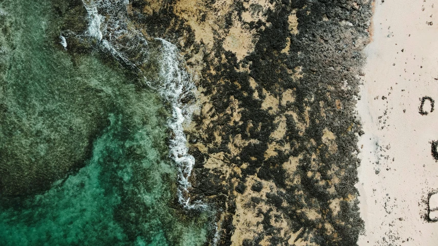 the water, dirt and sand are near an area that looks like a beach