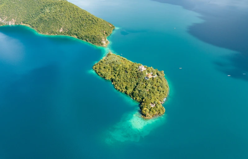 an island surrounded by clear water on a blue ocean