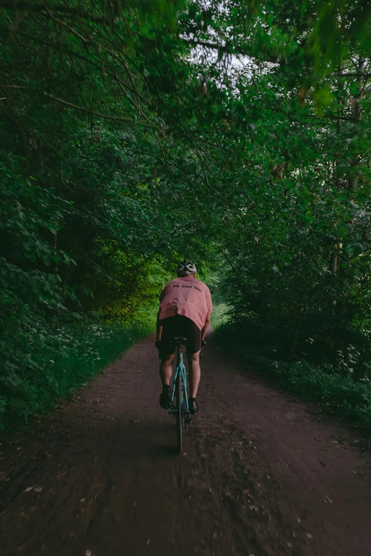 man riding his bicycle along the trail in the woods