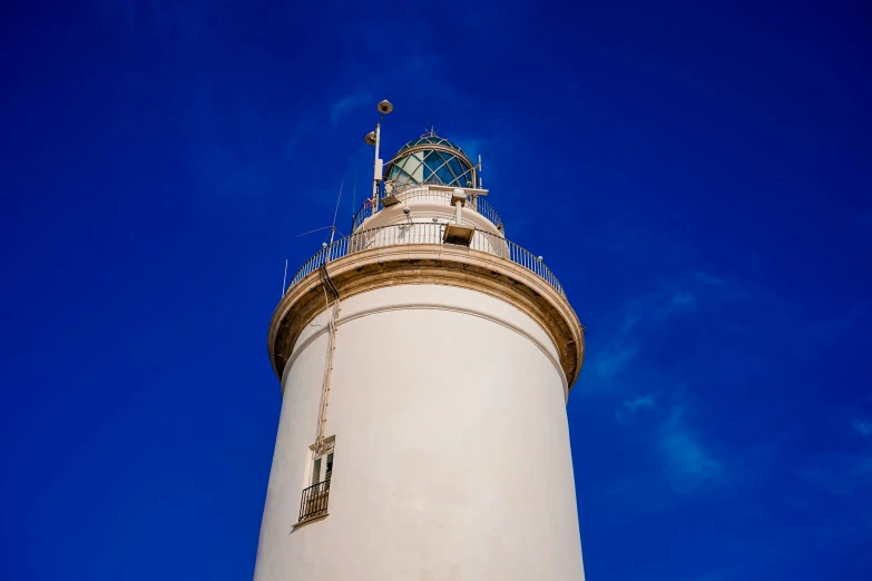 a tall white lighthouse with a clock on top