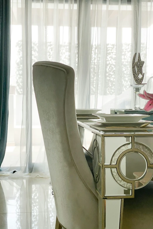 some chairs with a table and white curtains