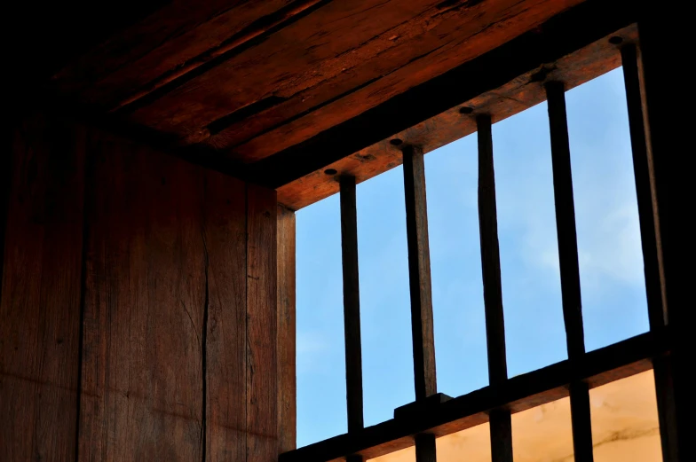 a blue sky viewed through a wooden window