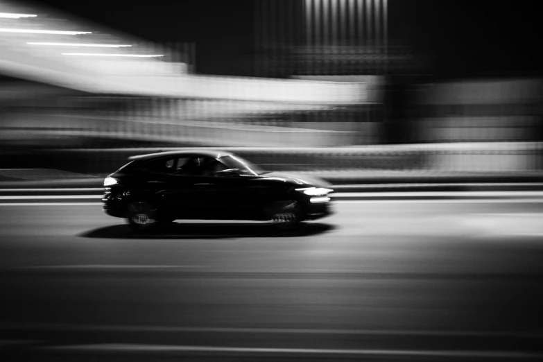 a small black car driving through the night