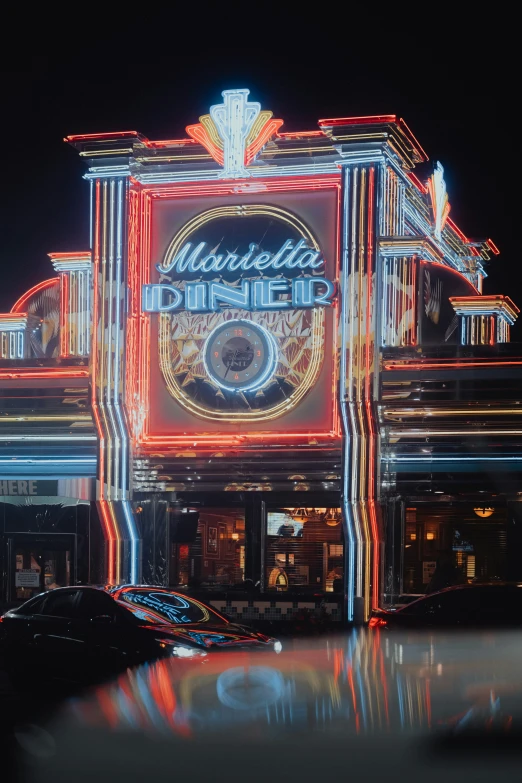 neon lights are on the exterior of a bar at night