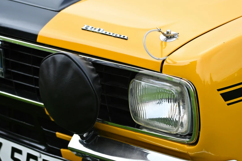 an old yellow truck with its headlights turned and emblem removed