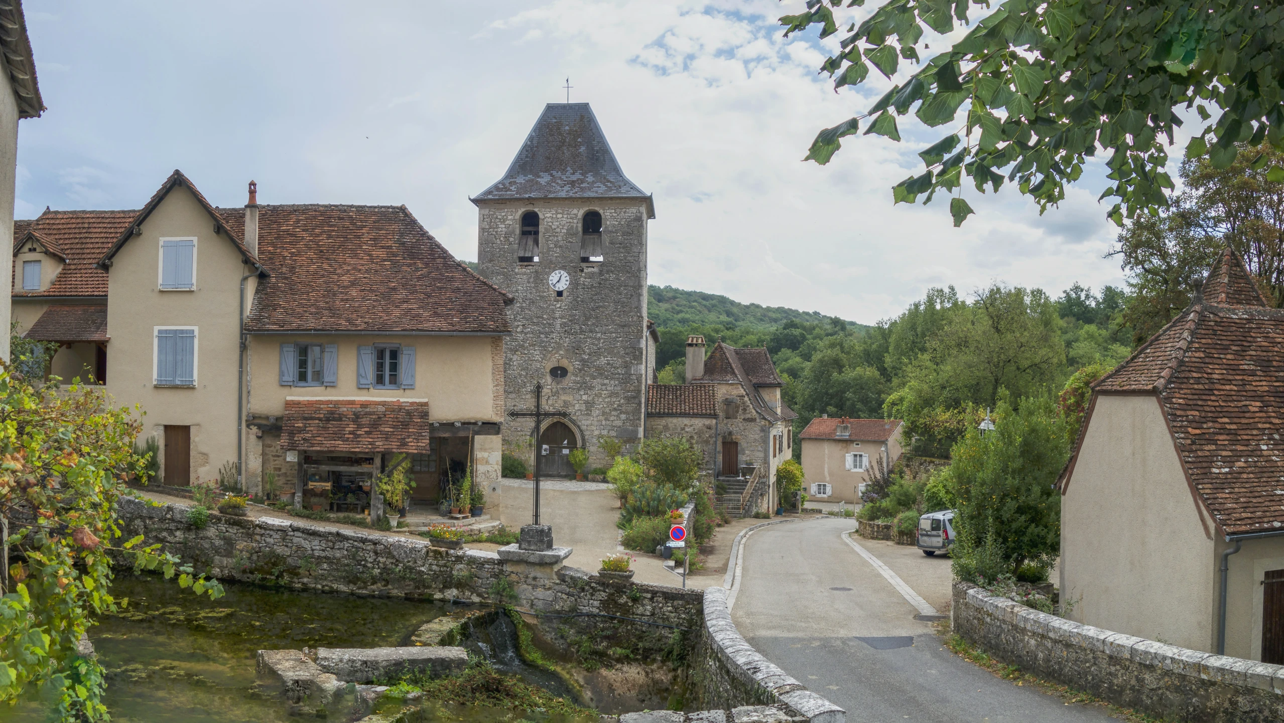 an old stone - framed clock tower towering over small houses