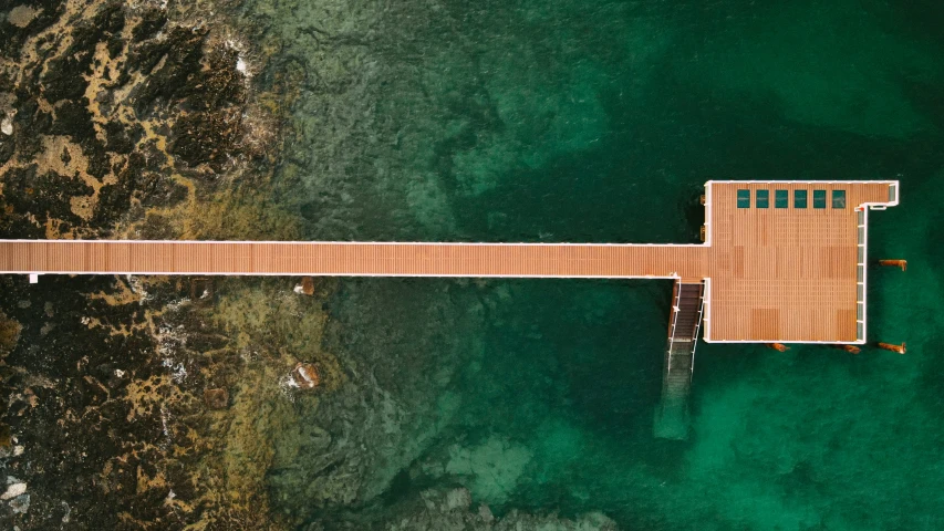 wooden bridge that extends into the ocean from above