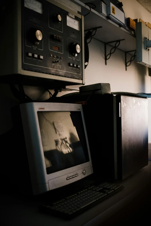 an old computer and a mini tv sitting in front of a shelf