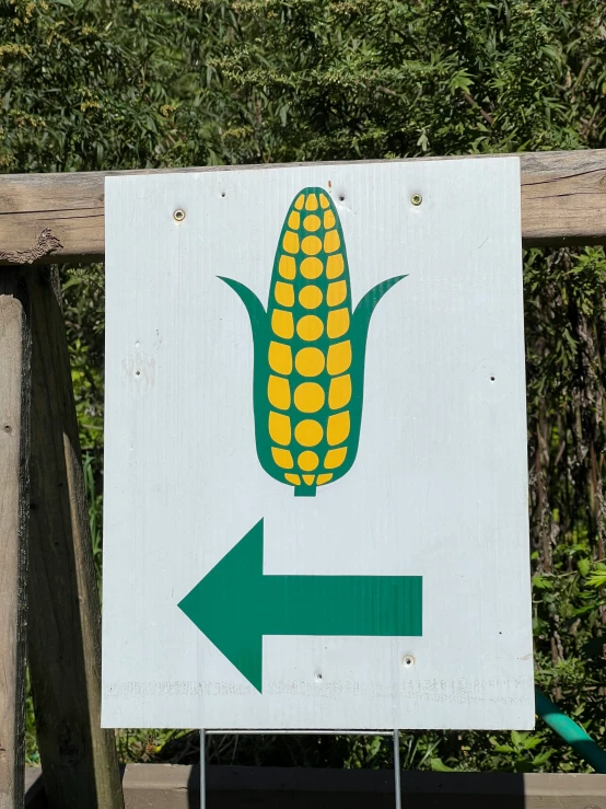 a sign pointing to a corn on the cob and arrows