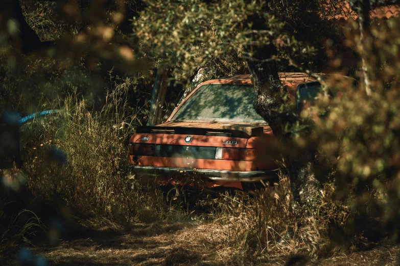 a burnt out car parked on top of a dirt field