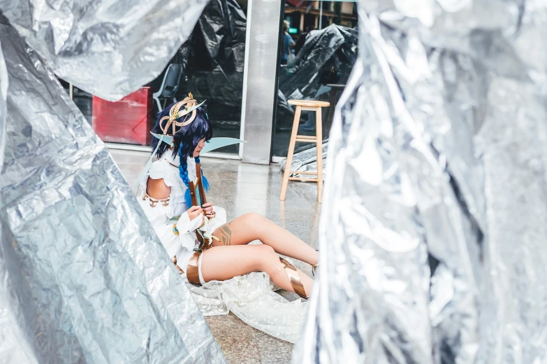 a woman laying on her stomach in a silver piece of covering