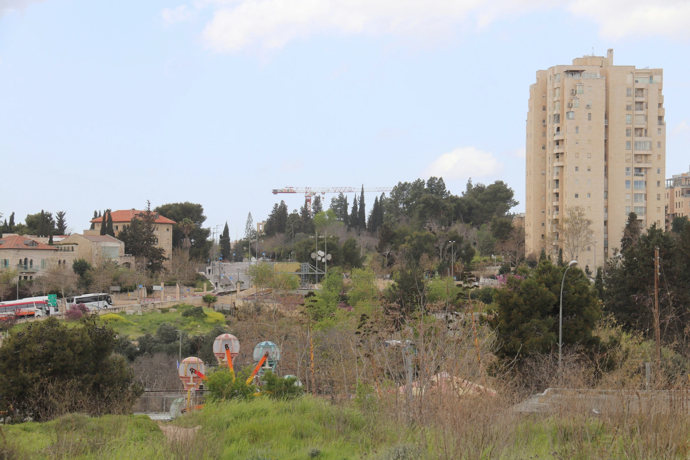 a view of a city in the distance, with skyscrs and green space