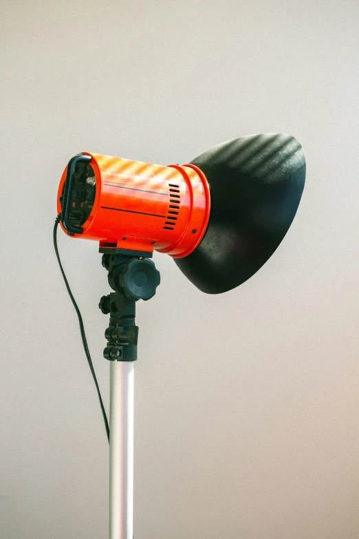 a red and black object on top of a white pole