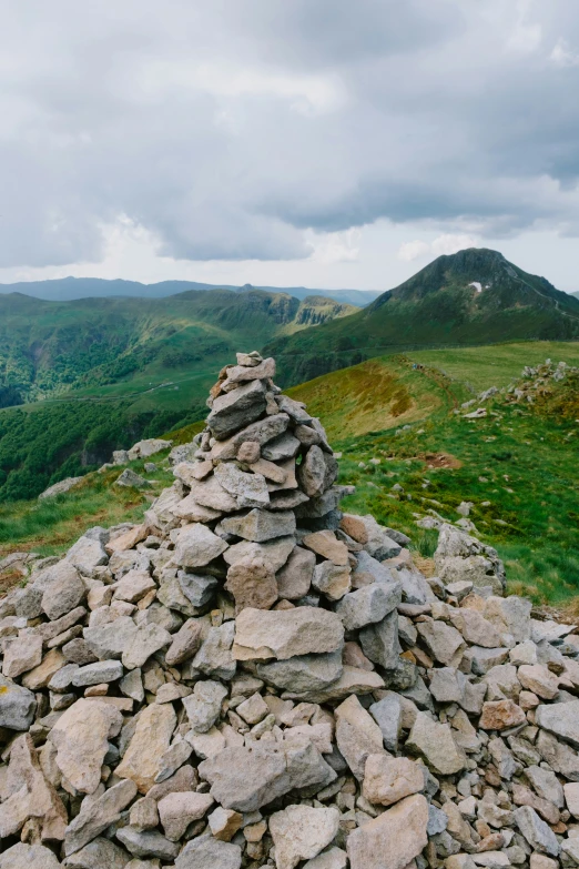 a pile of stones with a view over some hills