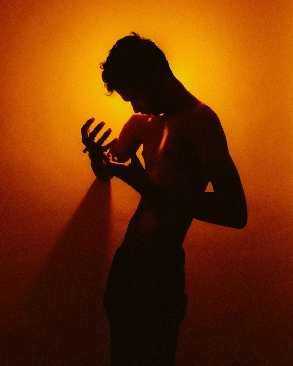 a silhouetted person with a phone in his hand