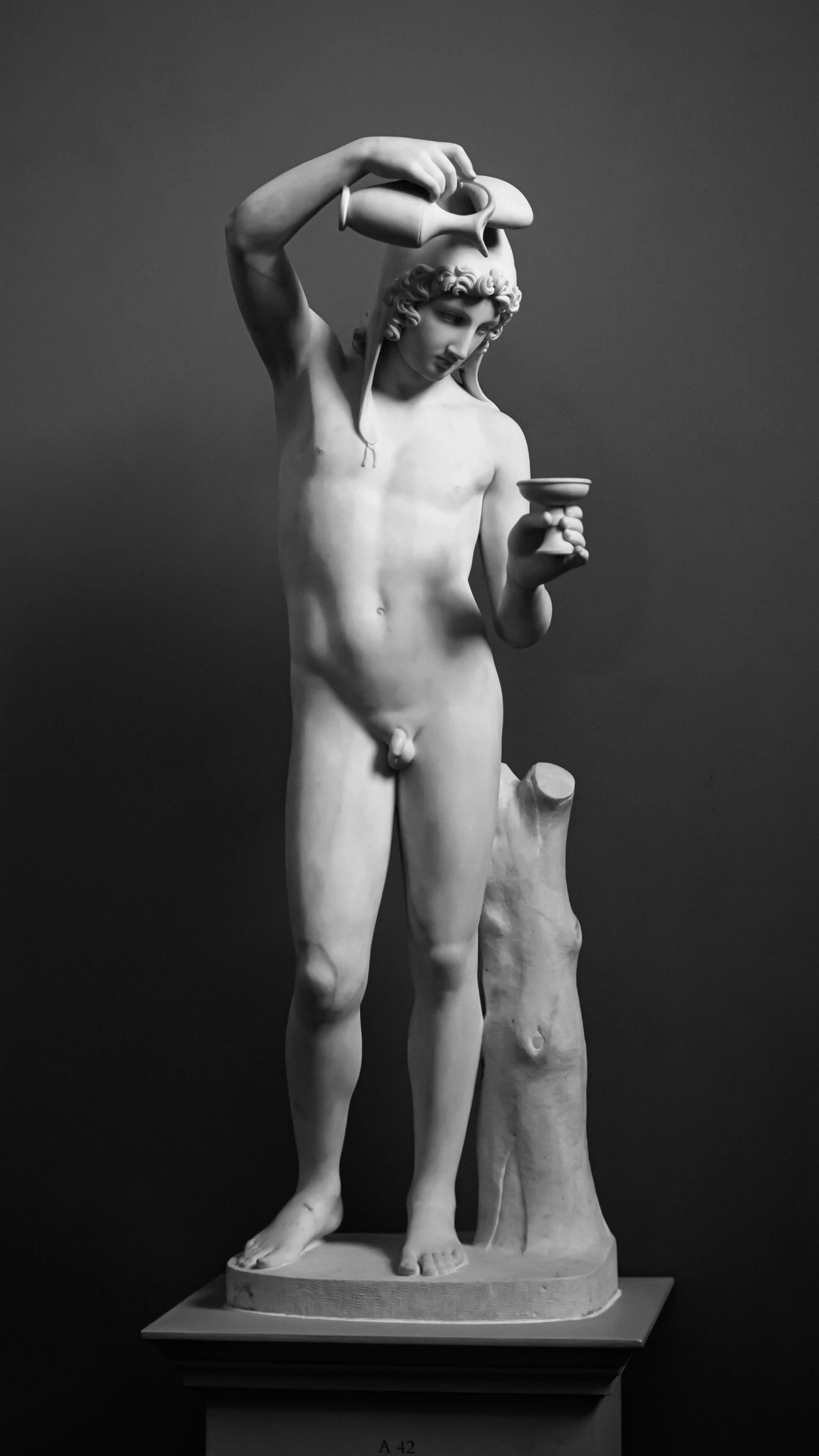 a statue of an individual holding a cup in their hands